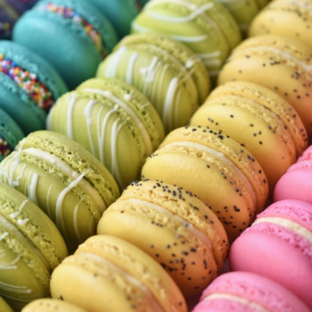 A colorful assortment of French macarons featuring: cake batter, key lime white chocolate, lemon poppyseed, and jasmine.