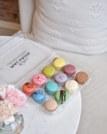 A box of 12 macarons, sitting on a table