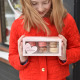 Girl holding box of 6 French macarons in custom Valentine box available in Grand Rapids, Ann Arbor and Holland Michigan.