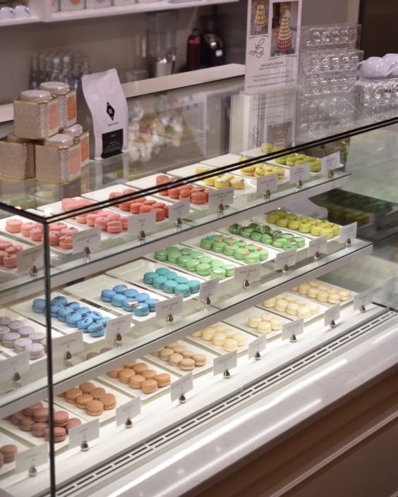 Macaron Case A view of the bakery case of macarons in the Le Bon Macaron Holland storefront, featuring an array of colors.